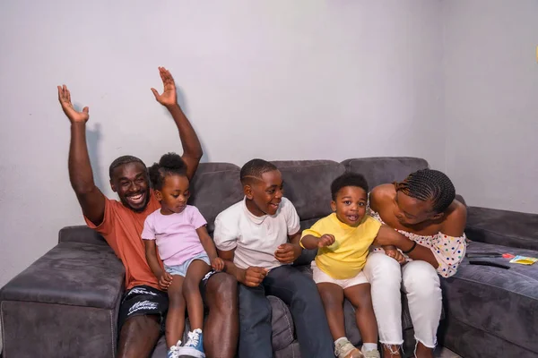 아이들 소파에 텔레비전에서 스포츠를 즐기는 아프리카 가족의 — 스톡 사진