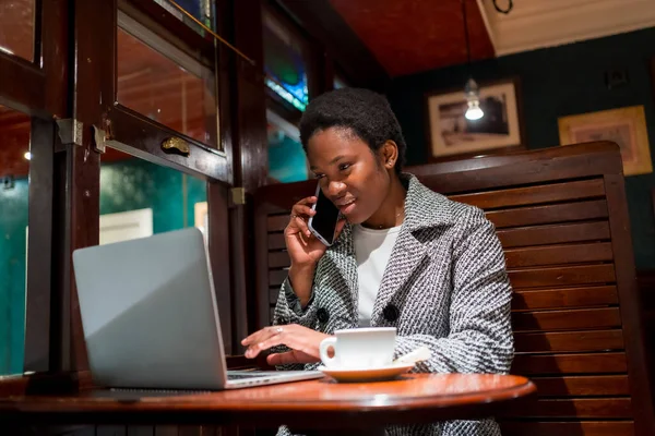 Bizneswoman Pochodzenia Afrykańskiego Kawiarni Finansistka Komputerem Rozmawiająca Przez Telefon — Zdjęcie stockowe