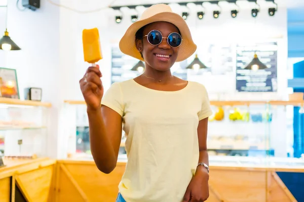 Αφρικανική Μαύρη Εθνικότητα Γυναίκα Τρώει Ένα Παγωτό Μάνγκο Ένα Κατάστημα — Φωτογραφία Αρχείου