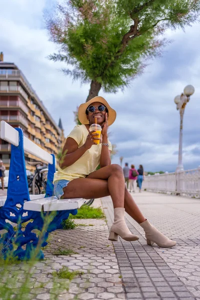 Μαύρη Γυναίκα Που Πίνει Χυμό Καθισμένη Ένα Παγκάκι Στην Πόλη — Φωτογραφία Αρχείου
