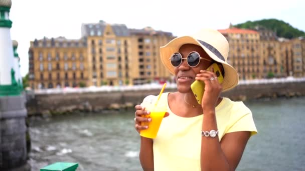 Чорна Етнічна Жінка Помаранчевий Сік Смс Телефоном Турист Насолоджується Літом — стокове відео