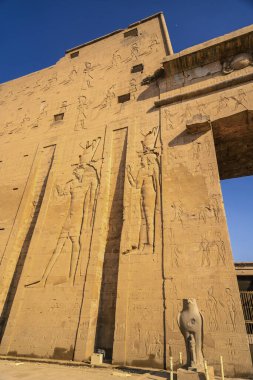 Edfu, Mısır 'daki Edfu Tapınağı' nın firavunlarının çizimiyle yüz yüze. Nil nehrinin kıyısında, kertenkele-Roma inşaatı, Huros 'a adanmış tapınak.