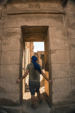 Aswan şehrinin yakınlarındaki Edfu Tapınağı 'nın girişinde mavi sarıklı genç bir adamın portresi. Mısır, Nil 'in batı kıyısı Edfu şehrinde, Greko-Romen inşaatı, Horus' a adanmıştır.