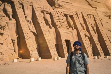 Mısır 'ın güneyindeki Abu Simbel yakınlarındaki Mısır Nefertari Tapınağı' nı ziyaret eden mavi türbanlı genç bir adam Nubia 'da Nasser Gölü' nün yanında. Firavun 2. Ramses Tapınağı, seyahat yaşam tarzı.