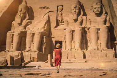 Kırmızı elbiseli genç bir turist Nubia 'daki Abu Simbel Tapınağı' na giriyor Nasser Gölü 'nün yanındaki. Firavun 2. Ramses Tapınağı