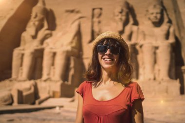 Mısır 'ın güneyindeki Abu Simbel Tapınağı' nda Nasser Gölü 'nün yanındaki kırmızı elbiseli genç bir turist. Firavun 2. Ramses Tapınağı