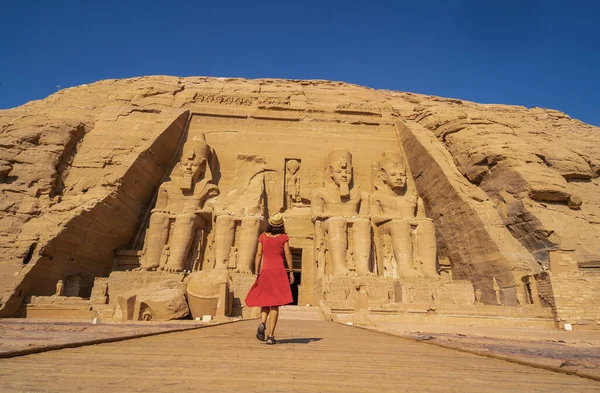 stock image A European tourist in red dress at the Abu Simbel Temple in southern Egypt in Nubia next to Lake Nasser. Temple of Pharaoh Ramses II, travel lifestyle