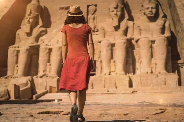ヌビアのナセル湖の隣にあるエジプト南部のアブ シンベル寺院に入る赤いドレスの若い観光客 ファラオ ラムセス2世神殿 — ストック写真