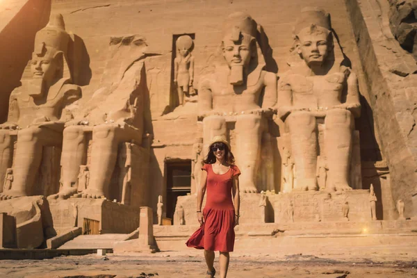 ヌビアのナセル湖に隣接するエジプト南部のアブ シンベル寺院を去る赤いドレスの若い観光客 ファラオ ラムセス2世神殿 — ストック写真