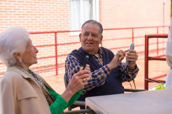 Huzurevinin Bahçesinde Çok Mutlu Iki Yaşlı Insan Telefona Bakıyor Yaşlılarda — Stok fotoğraf