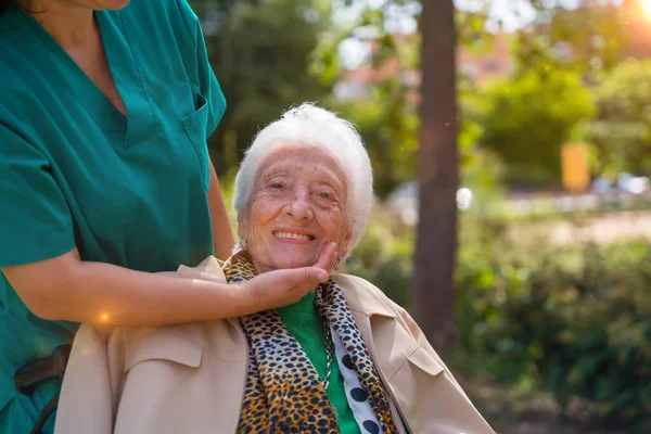 Egy Idős Nővérrel Sétálni Egy Öregek Otthonának Kertjében Kerekesszékben Természet — Stock Fotó