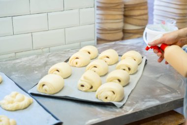 Esnaf fırınının atölyesindeki fırıncı Napoli çöreklerini kahvaltıya hazırlıyor.