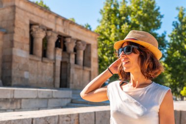 Mısır 'ın Madrid şehrindeki Debod Tapınağı' nda eski Mısır tapınağında şapkalı genç bir turist kadın.