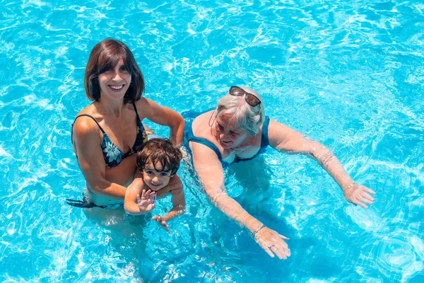 stock image Mother and grandmother having fun with grandson in swimming pool on summer vacation