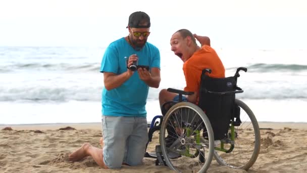 Uma Pessoa Com Deficiência Uma Cadeira Rodas Praia Com Amigo — Vídeo de Stock