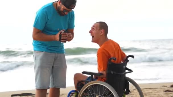 Osoba Niepełnosprawna Wózku Inwalidzkim Plaży Zabawia Się Przyjacielem Kamerą Wideo — Wideo stockowe