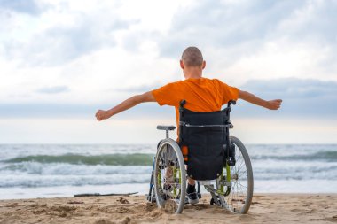 Tekerlekli sandalyede sırtüstü yatmış engelli bir insan kendini özgür hissediyor.