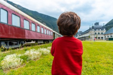 Çocuk arkadan Pireneler 'deki eski Canfranc tren istasyonuna bakıyor. İspanya