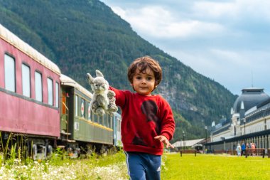 Pireneler 'deki Canfranc tren istasyonunda oyuncak bir hayvanla eğlenen bir çocuk. İspanya