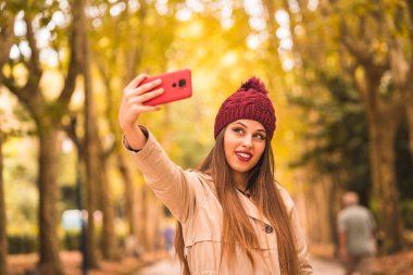Portrait of a beautiful woman in autumn together in a forest in nature on a video call