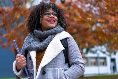 Portrait of black ethnic girl strolling in college college in fall back to school
