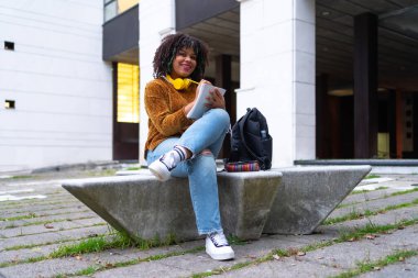 Portrait of black ethnic girl sitting in college doing class work