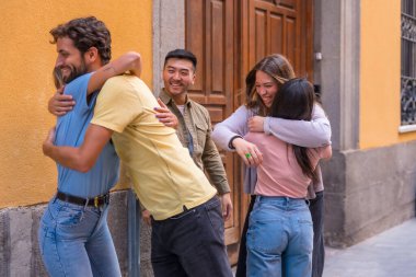 Bir grup çok ırklı arkadaş şehirde selamlaşıp öpüşüyorlar. Erkekler ve kızlarla arkadaşlık kuruyorlar.