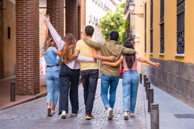 Şehirde arkadan sarılan bir grup çok ırklı arkadaş. Erkekler ve kızlarla arkadaşlık kavramı.