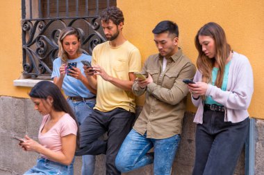 Şehirdeki telefona ciddi bakan çok ırklı arkadaş grubu, gençlik kavramı cep telefonuna takıldı.
