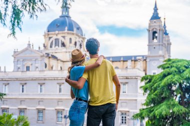 Yaz tatilinde Madrid 'i ziyaret eden turist çift. Gezginler için tatil konsepti, sırtları Almudena 'ya bakıyor.