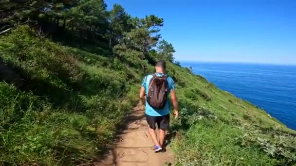 一个年轻人走在从帕萨伊圣佩德罗到基普兹科阿省圣塞巴斯蒂安的乌里亚山小径上 — 图库视频影像