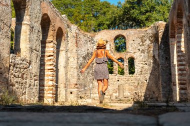 Butrint veya Butrinto Ulusal Parkı 'ndaki Büyük Bazilika' da yürüyen kadın turist