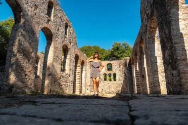 Arnavutluk 'un Butrint veya Butrinto Ulusal Parkı' ndaki Büyük Bazilika 'da yürüyen çok mutlu bir bayan turist
