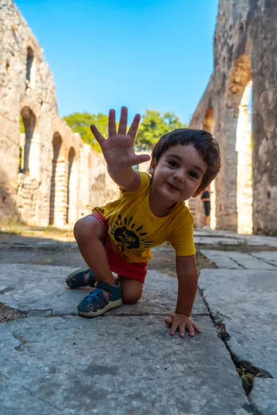 Arnavutluk 'taki Butrint veya Butrinto Ulusal Parkı arkeolojik kalıntılarında Büyük Bazilika' da oynayan bir çocuk