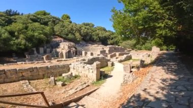 Arnavutluk 'taki Butrint veya Butrinto Ulusal Parkı' nın arkeolojik kalıntılarında tiyatronun girişinde geziniyor.