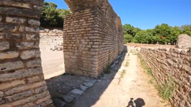 Arnavutluk 'taki Butrint veya Butrinto Ulusal Parkı' nın arkeolojik kalıntılarında tiyatronun girişinde geziniyor.