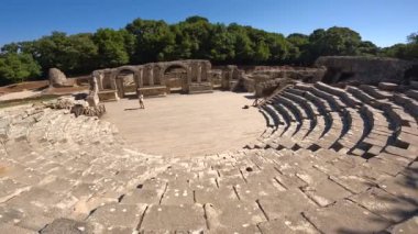 Arnavutluk 'taki Butrint veya Butrinto Ulusal Parkı' nın arkeolojik kalıntılarında tiyatronun girişinde geziniyor.