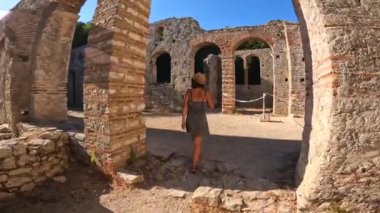 Arnavutluk 'taki Butrint veya Butrinto Ulusal Parkı arkeolojik kalıntılarında Büyük Bazilika' yı ziyaret eden bir turist