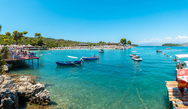Туристы на пляжах Ксамиля в Албанской ривьере наслаждаются летними каникулами