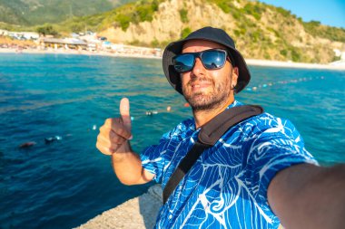 Arnavutluk 'un Vlore kenti yakınlarındaki Arnavut Rivierası sahilindeki genç bir adamın selfie' si