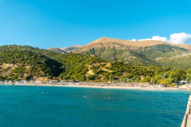 Arnavutluk 'ta yaz tatilinde Vlore yakınlarında güneşli yataklı Arnavut Riviera plajı