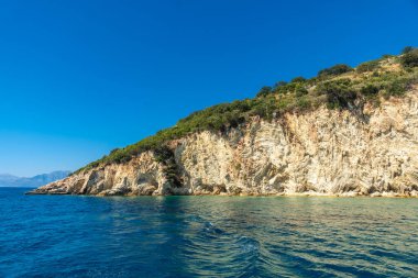 Sarande yakınlarındaki Arnavut Rivierası 'ndaki tekneden görülen güzel Gremina plajı, turkuaz deniz suyu
