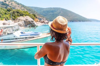  Arnavutluk 'un Sarande kentindeki Arnavut Rivierası' ndaki tekneden cennet sahili Kroreza veya Krorez 'e bakan turist kadın