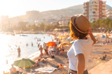 Sarande 'de gün batımında bir turist kadının portresi veya Arnavutluk' un Riviera kentinde Saranda