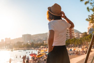 Arnavutluk 'un başkenti Arnavutluk' un bulvarında yürüyen Sarande veya Saranda 'da gün batımında bir turist kadının portresi