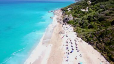 Lefkada 'daki kumlu Megali Petra plajındaki temiz turkuaz ve mavi suda insansız hava aracı görüntüsü. Yunanistan
