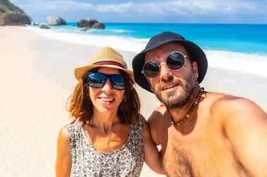 Yazın mutlu bir kadın, Yunanistan 'ın İyon Denizi' ndeki Lefkada adasının turkuaz denizine bakıyor.