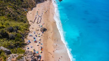 Lefkada 'daki kumlu Megali Petra plajındaki temiz turkuaz ve mavi suda insansız hava aracı görüntüsü. Yunanistan