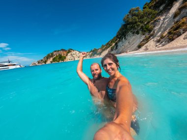 Akdeniz 'deki İyon Denizi' ndeki Ithaki veya Ithaca adasındaki Gidaki Plajı 'nda eğlenen bir turist çiftin selfie' si.