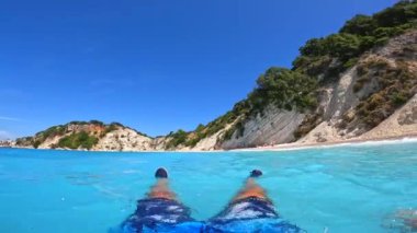 Turist, Akdeniz 'deki İyon Denizi' ndeki Ithaki ya da Ithaca adasındaki Gidaki Plajı 'nda suda eğleniyor.